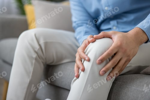 Preview: Man experiencing knee pain applying pressure on leg