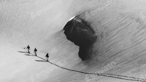 Preview: Grayscale beautiful view of skiers on a snowy mountain during sunrise