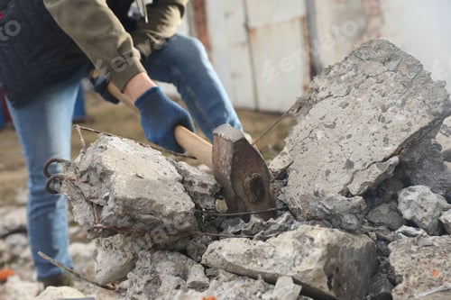 Preview: Man breaking stones with sledgehammer outdoors, closeup