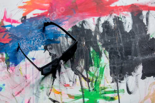 Preview: sunglasses on a art paint as background. Above view