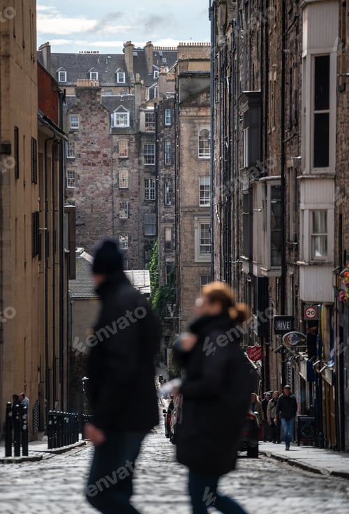 Preview: two people walking across the street while the other walks down the street