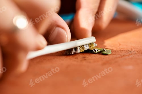 Preview: close up view of professional repairman cleaning chipset with brush in workshop, small business