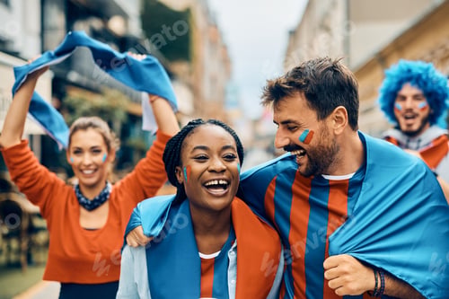 Preview: Cheerful couple of sports fans having fun on the street during the world cup.
