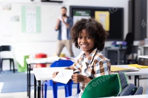 Visualização: Estudante afro-americano sorridente na mesa na sala de aula do ensino fundamental, com espaço de cópia
