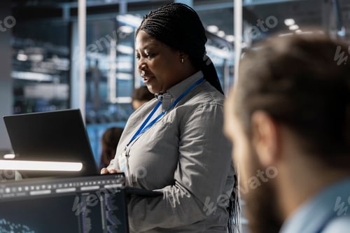 Preview: Technician using laptop to oversee server infrastructure