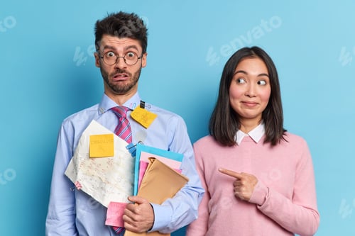 Preview: Satisfied Asian woman points at her groupmate who has very shocked expression realises he has deadli