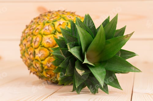 Fresh Whole Pineapple on Light Wooden Background