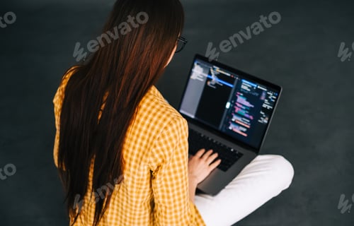 Preview: Young woman mobile developer writes program code on a computer, programmer work.
