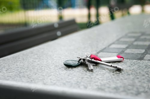 Preview: Keys forgotten on grey stone table outdoors. Space for text. Lost and found
