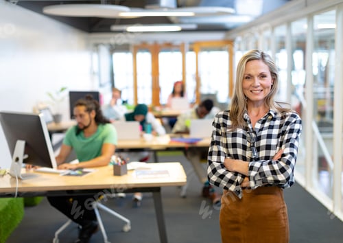 Preview: Front view of happy Caucasian businesswoman with arms crossed looking at camera in a modern office