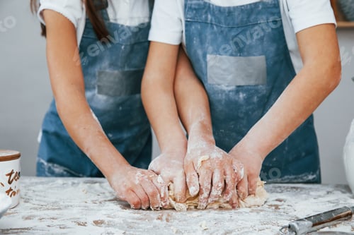 Preview: Close up view of two little girls in blue chef uniform that preparing food on the kitchen