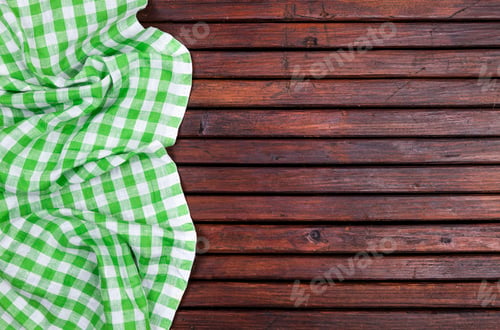 Preview: Green checkered tablecloth on dark wooden table with, top view with copy space