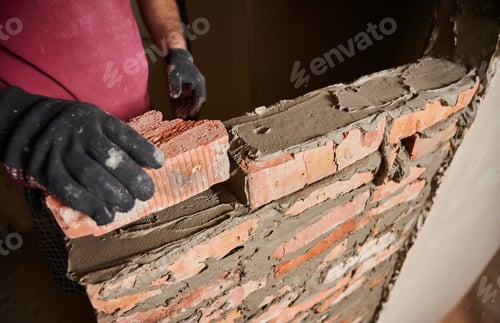 Preview: Bricklayer worker building brick wall at construction site.