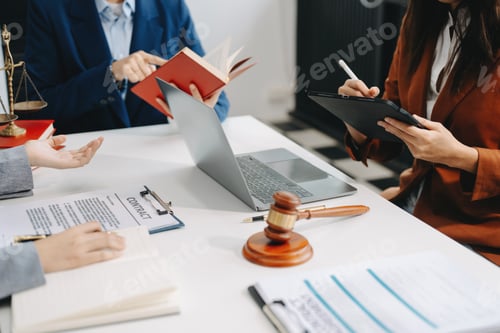 Preview: business people and lawyers discussing contract papers sitting at the table.