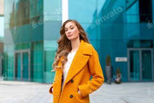 Preview: Business woman dressed yellow coat standing outdoors corporative building background