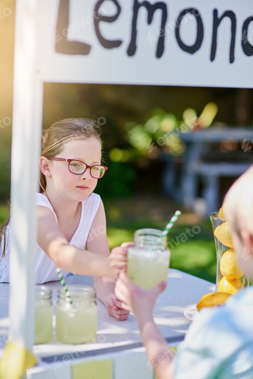 Preview: Cropped shot of a little girl selling lemonade from her stand outside