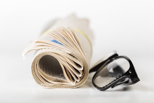 Preview: Reading news with glasses on a table in a bright room during morning hours