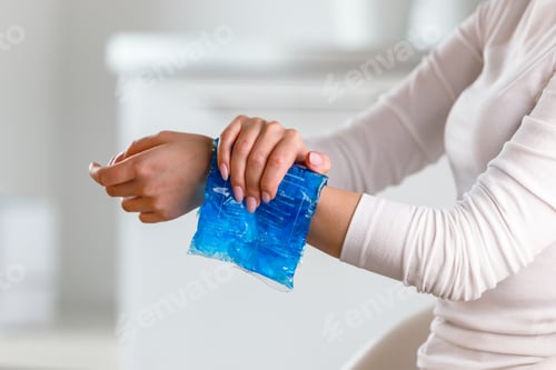 Preview: Woman applying cold compress to a her painful wrist
