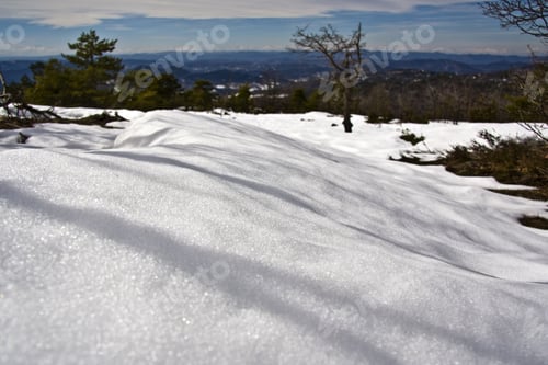 Preview: Close shot of snowy hill with blurred trees in the background