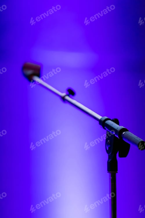Preview: Selective focus shot of a microphone standon a bright blue background
