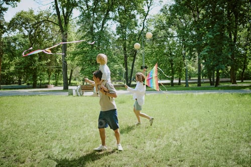 Preview: Diverse Family with Child Flying Kite and Walking Together in Park