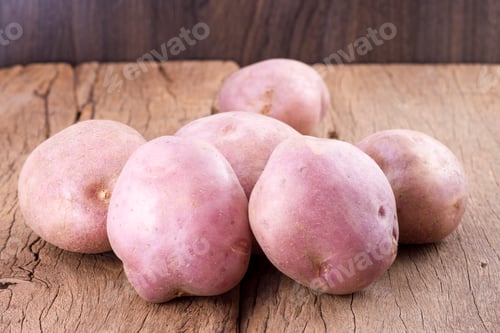 Preview: stack of potatoes on wooden table (Solanum tuberosum)