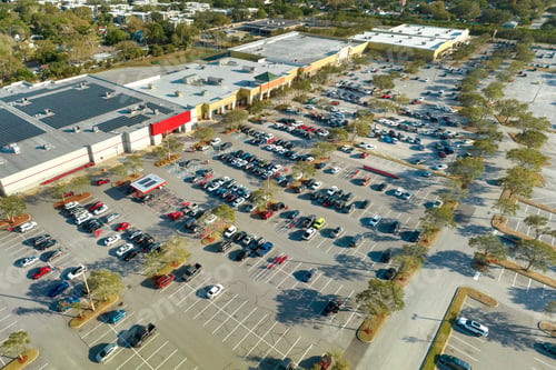 Preview: Aerial view of many cars parked on parking lot in front of a grocery mall store