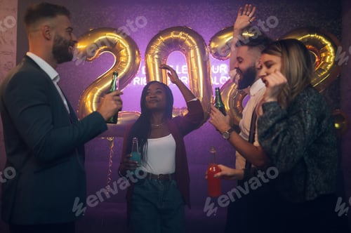 Preview: Happy group of friends celebrate New Year's Eve while dancing in the club
