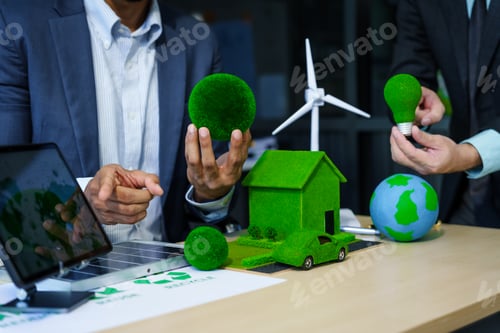 Preview: A meeting at an office desk focuses on teamwork with a house model and discussions on electric cars
