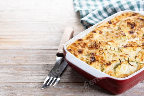Vista previa: Casserole with cheese and gratin zucchini on wooden table