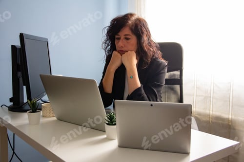 Preview: Business woman working in her office at home, laptops, thinking, home office, remote work, worried