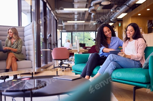 Preview: Businesswomen Having Informal Meeting In Breakout Seating Area Of Modern Office