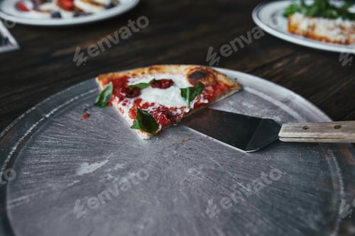 Preview: slice of tasty pizza with server on metal tray and wooden table