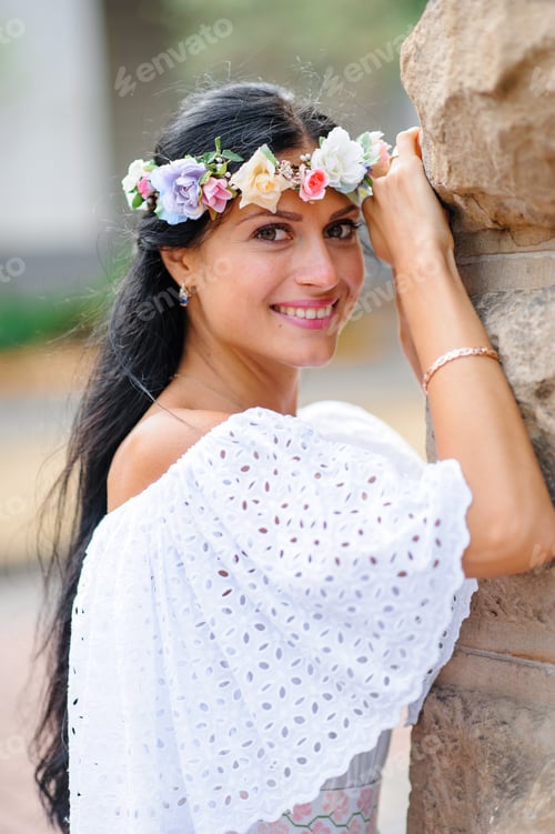 Preview: Wedding photo shoot. Portrait of a charming bride in a wreath on her head.