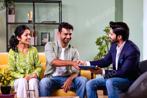 Preview: Indian family investment consultation at home with professional agent reviewing paperwork