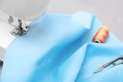 Preview: Sewing machine with fabric on table in tailor workshop, closeup