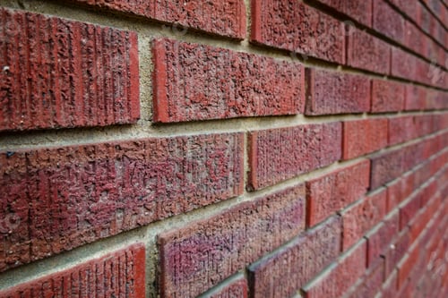 Preview: Close-up of an old clay red brick wall, laid in a running bond pattern with mortar.