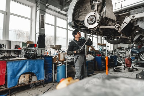 Preview: Auto mechanic repairs running gear of a car in car service