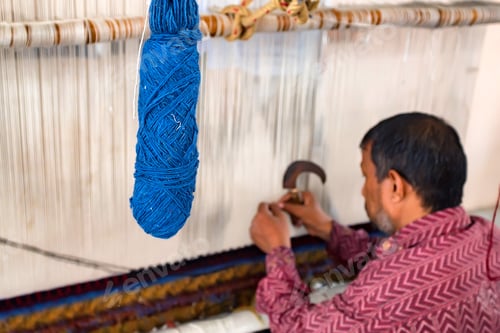 Preview: Back view man weaves carpet