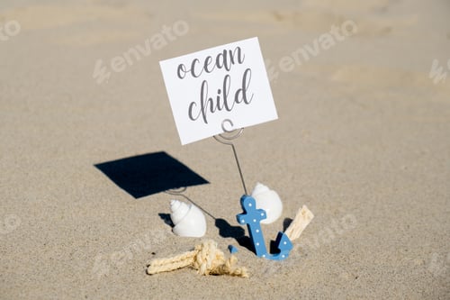 Preview: OCEAN CHILD text on paper greeting card in anchor paper holder and starfish seashell summer vacation