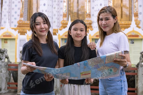 Preview: Teenage girls discuss a tourist map of popular temples in Asia