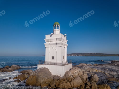 Preview: Shelley Point lighthouse on a rocky beach on a sunny day in South Africa