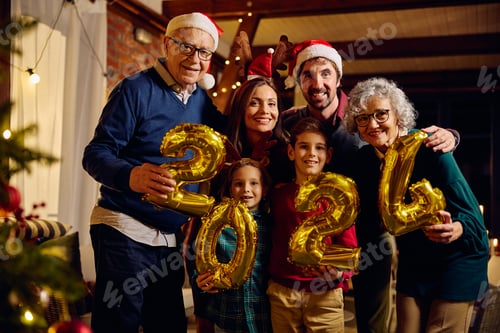 Visualização: Feliz família multigeracional comemorando o Ano Novo de 2024 em casa e olhando para a câmera.