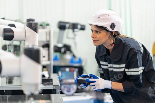 Preview: Female Engineer check and control automation robot arms machine in factory. robotics manufacturing.