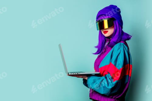 Preview: Stylish girl in cyber punk glasses and 80s tracksuit hold laptop computer on blue background