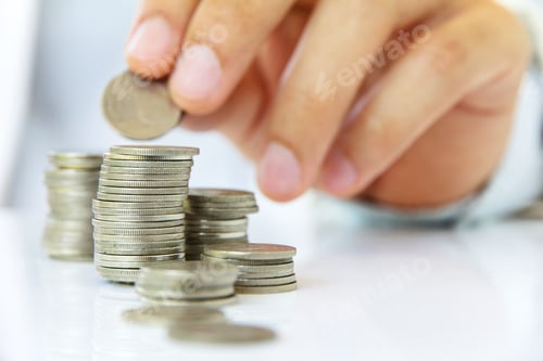 Preview: Hand Stacking Coins on White Background Close Up