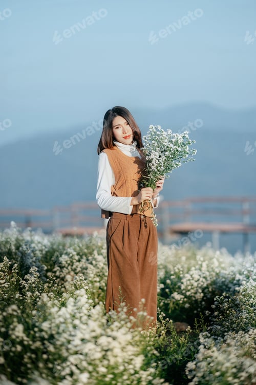 Preview: woman holding a bouquet of flowers in the morning light.
