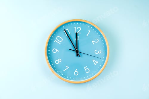 Preview: Closeup of colorful wall clock on blue background. Minimalist flat lay image of plastic wall clock .