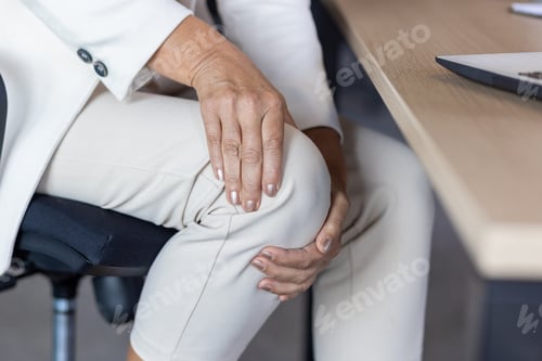 Preview: Close-up photo in the office at the desk. The hands of an older woman in a business suit are