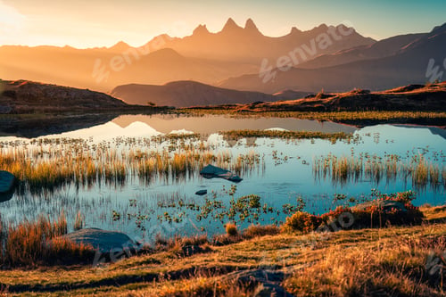 Preview: Sunrise shines over Lac Guichard with Arves massif and lake reflection in autumn at Aiguilles dArves